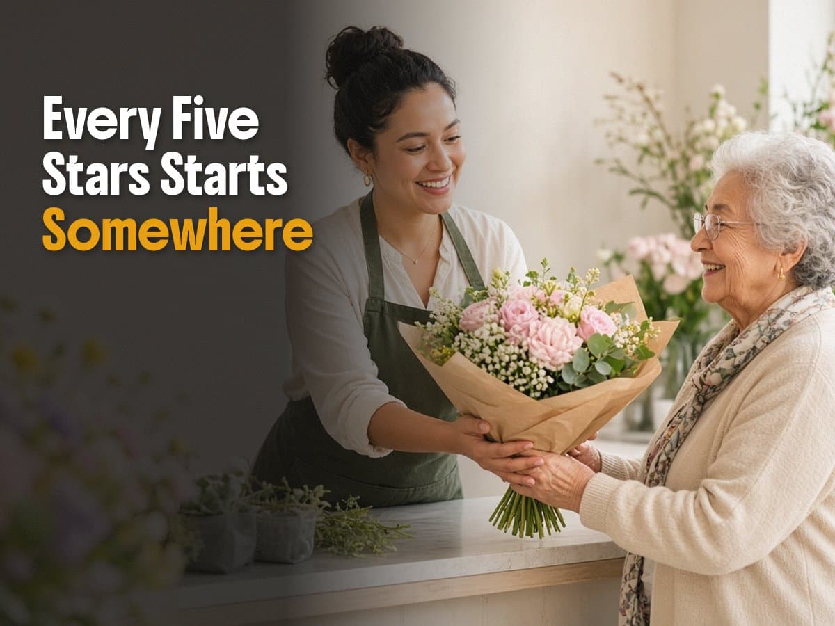 A florist in a green apron hands a pink rose bouquet to an older woman at a shop counter, beside the words Every Five Stars Starts Somewhere.