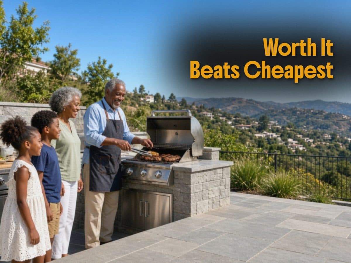 A family watches a man grill on a stone patio overlooking hills, beside the words Worth It Beats Cheapest.